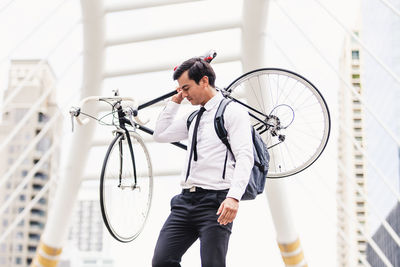 Man standing by bicycle