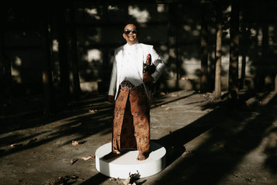 Full length portrait of man wearing sunglasses standing outdoors
