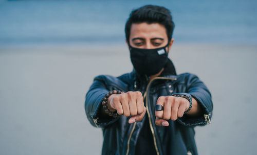 Man wearing mask while standing with clenching fist