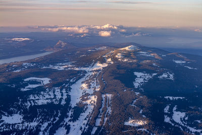 Aerial view of snowcapped mountains against sky during sunset