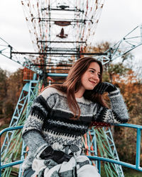 Smiling young woman sitting on ferris wheel