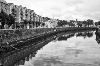 River amidst buildings in city against sky