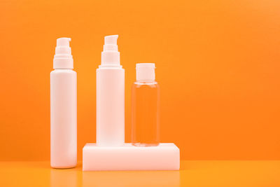 Close-up of bottles against orange background