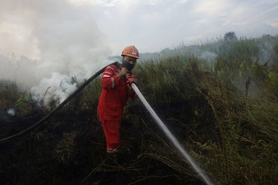 Rear view of firefighter working on field