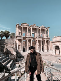 Full length of woman standing by historic building against sky