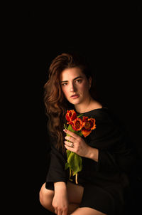 Portrait of young woman holding rose