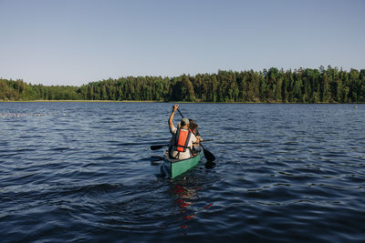 Counselor doing kayaking with kids on lake at summer camp