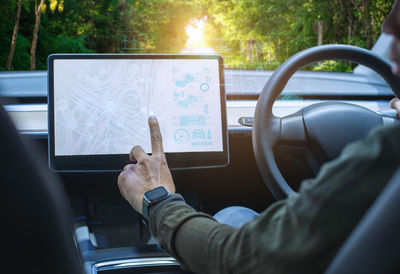 Midsection of woman using mobile phone while sitting in car