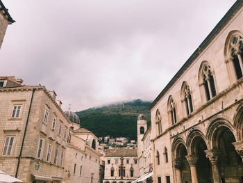 Low angle view of building against cloudy sky