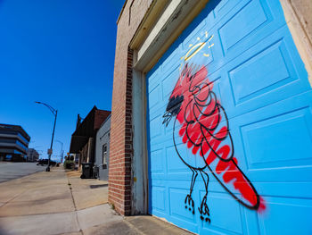 Low angle view of graffiti on building against sky