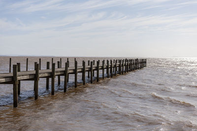 Pier over sea against sky, in the itapuã park, guaiba river, and the skyline in the background