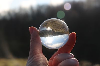 Close-up of hand holding crystal ball