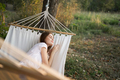 Midsection of woman sitting on hammock