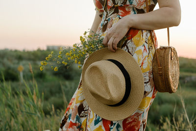 Rear view of woman wearing hat standing on field