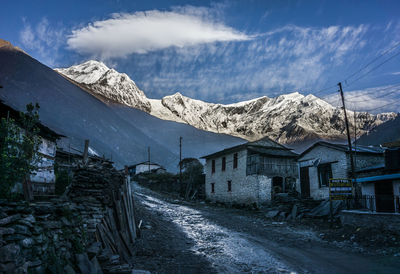 Road amidst buildings against sky during winter