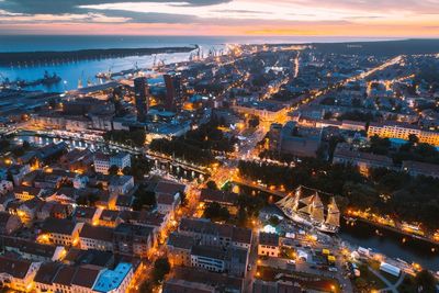 High angle view of illuminated cityscape against sky at sunset