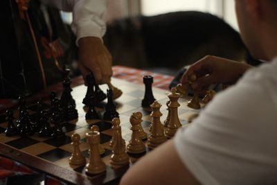 Midsection of people playing chess