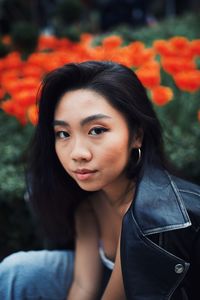 Portrait of beautiful young woman standing against plants