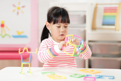 Cute girl playing with toy at home