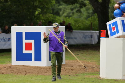 Man with umbrella standing on field