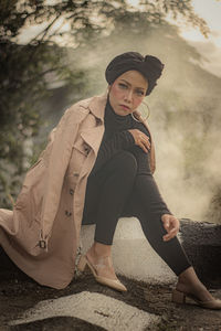 Portrait of young woman sitting on field