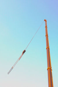 Low angle view of crane against clear sky