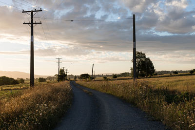 Road amidst field against sky