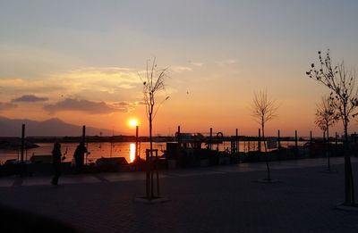 Silhouette beach against sky during sunset