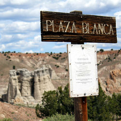 Information sign board against cloudy sky