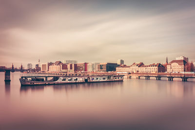 Boat over spree river in city against sky