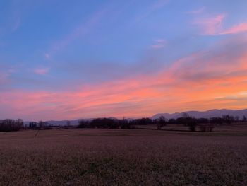 Scenic view of field against sky during sunset