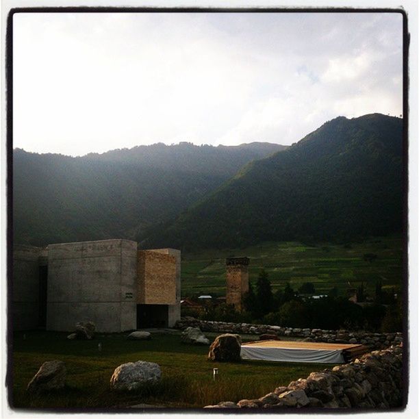 mountain, built structure, architecture, mountain range, transfer print, building exterior, landscape, sky, auto post production filter, history, grass, tranquility, house, nature, scenics, field, tranquil scene, hill, no people, outdoors