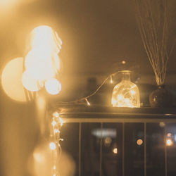 Close-up of illuminated light bulbs hanging from ceiling