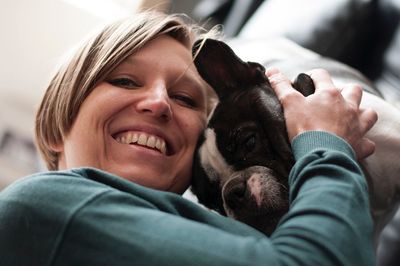 Low angle portrait of smiling woman with french bulldog