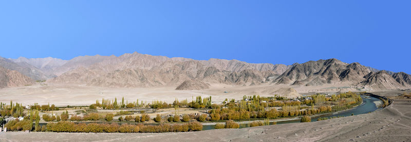 Scenic view of landscape against clear blue sky with the river, and mountain in leh-ladakh,  india.