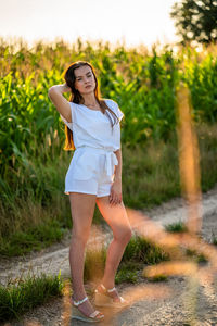 Portrait of young woman standing on field