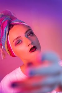 Portrait of beautiful young woman against colored background