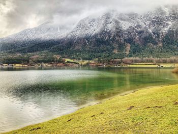 Scenic view of lake by mountains against sky