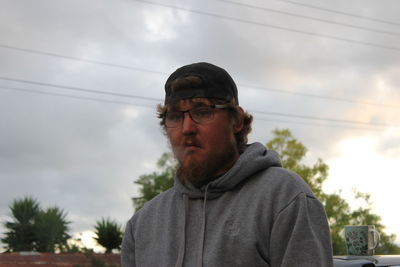 Portrait of man wearing eyeglasses against sky