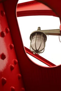 Low angle view of red telephone against sky