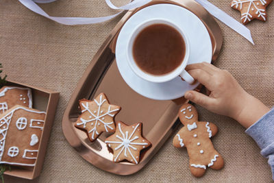 Christmas cozy home. kid holds cocoa and christmas gingerbread cookies. aesthetics winter baking