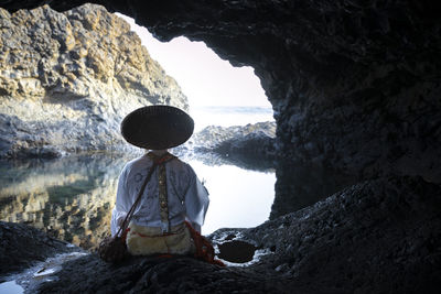 Rear view of man standing in cave