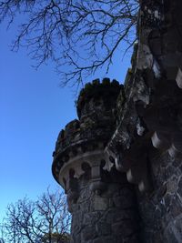 Low angle view of rocks against clear blue sky