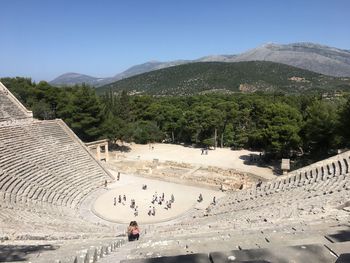 People at the great theatre of epidaurus on sunny day