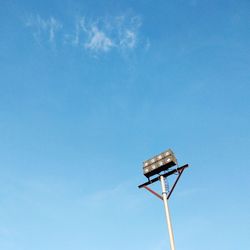 Low angle view of floodlight against blue sky