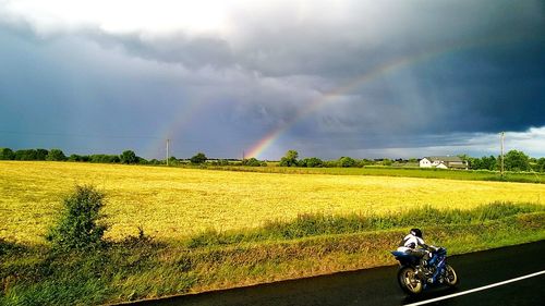 Scenic view of field against cloudy sky