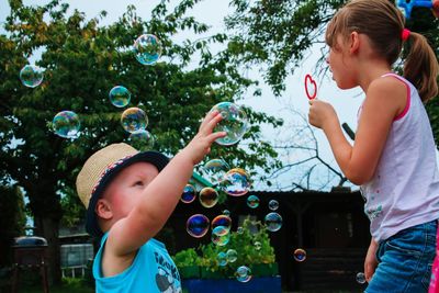 Girl playing with bubbles in park