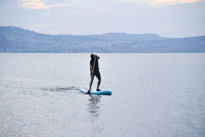 Full length of boy on sea shore against sky