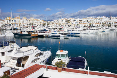 Boats moored in harbor by buildings in city