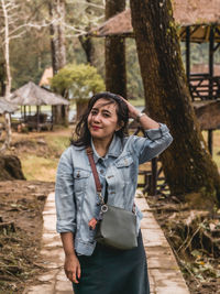 Portrait of young woman standing in forest